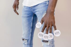 Close-up of a person holding vote stickers, emphasizing the importance of voting.